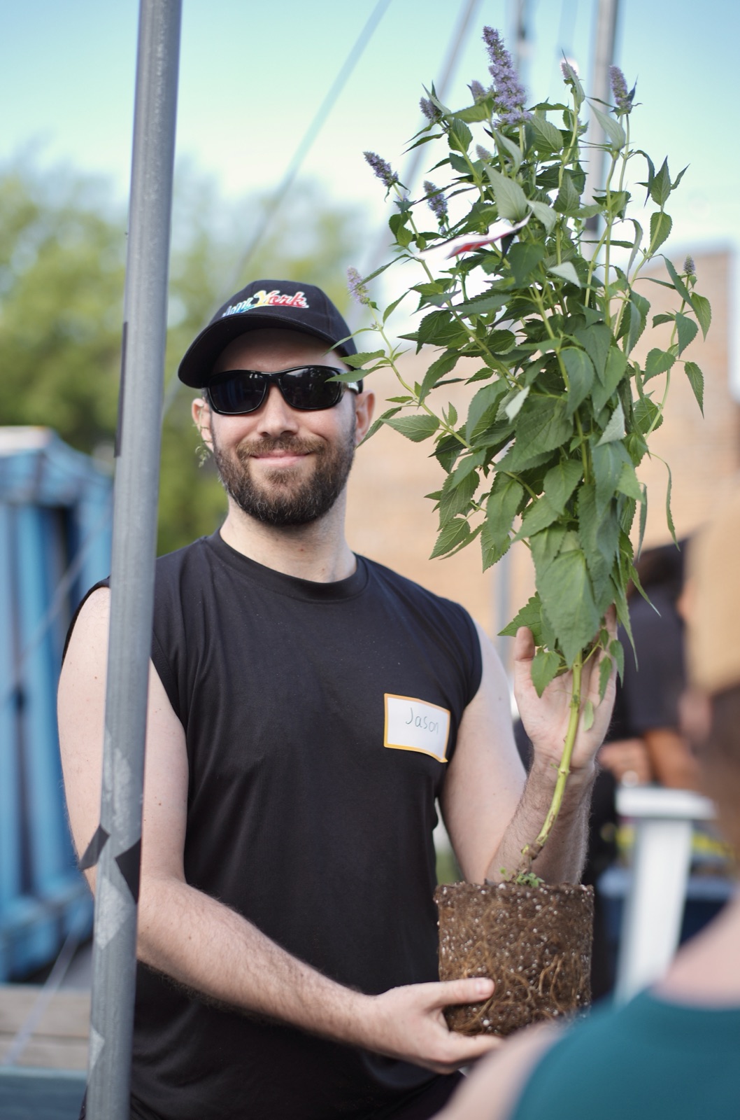 An attendee shows off a tall anise hyssop before planting it.