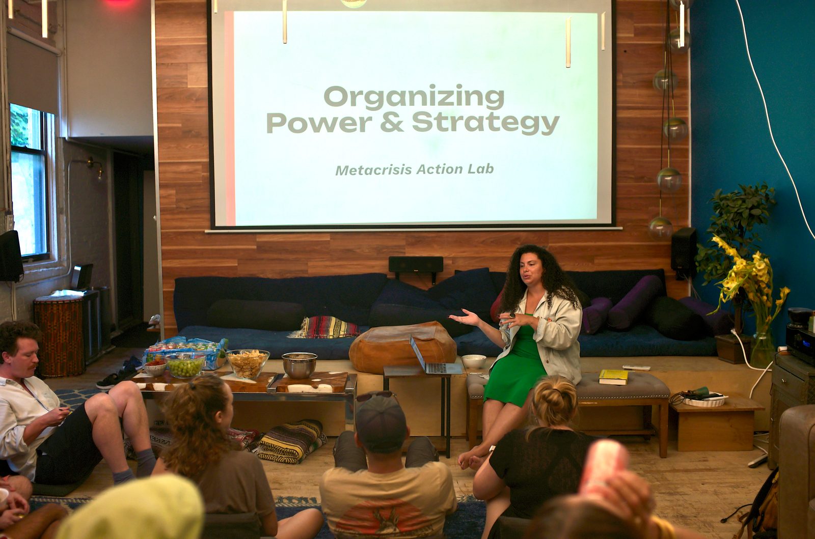 Allison King opens under the projected title slide, Organizing Power & Strategy, with the room settled onto floor cushions and the snack table in easy reach.