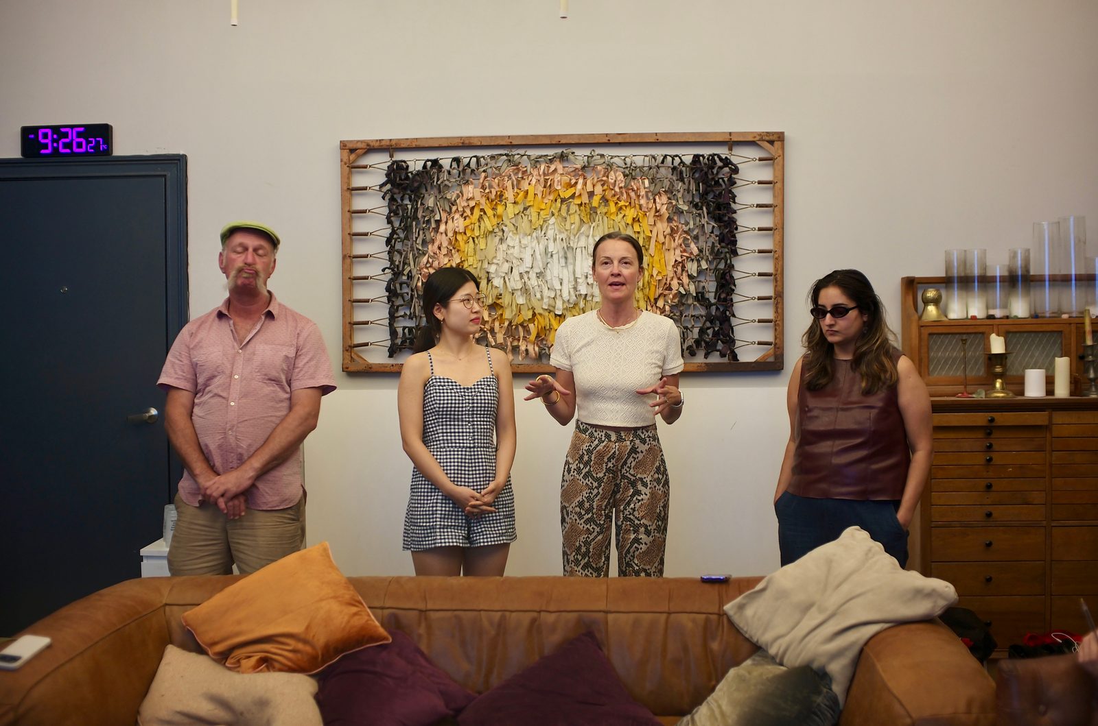 9:26 pm by the wall clock: a breakout group stands in front of the woven wall piece to present, role-playing testimony to the business district.
