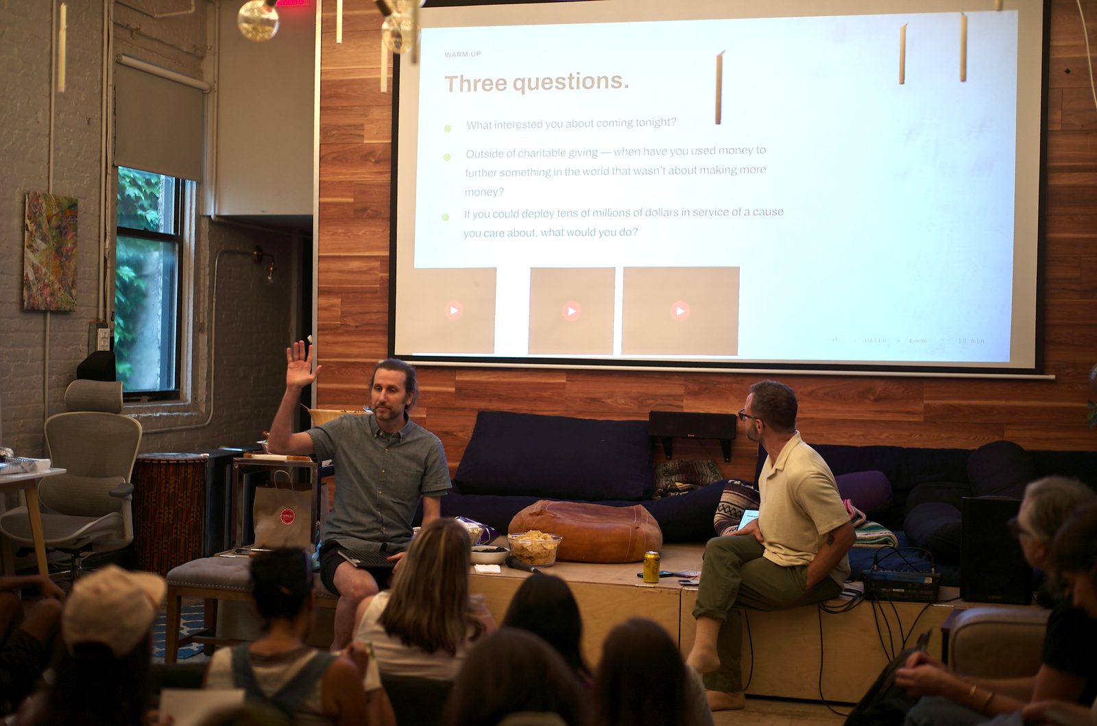 The Three Questions slide projected over the room while people write their answers on loose paper.