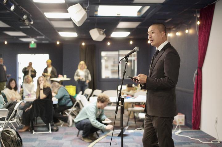 Supervisor Alan Wong speaks to a room still building