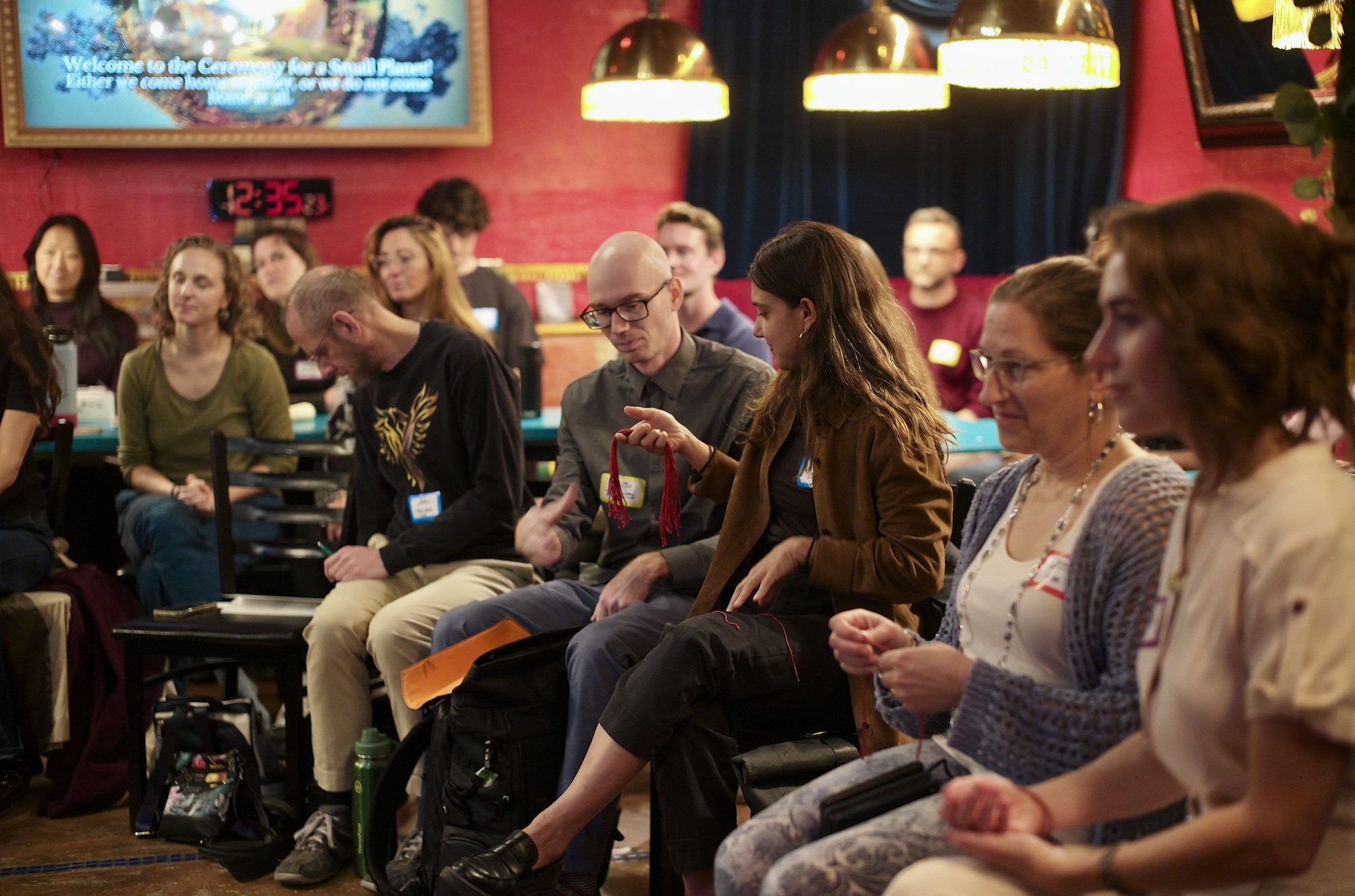 Samantha Sweetwater mid-talk, the room seated on every surface under the string lights.