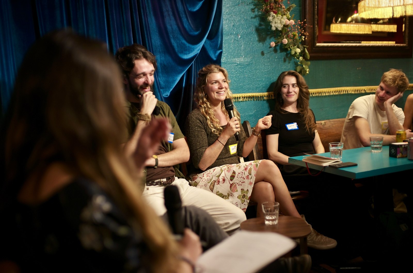 Sophia Rokhlin laughing into the microphone, Jeremy D Johnson and the panel beside her.