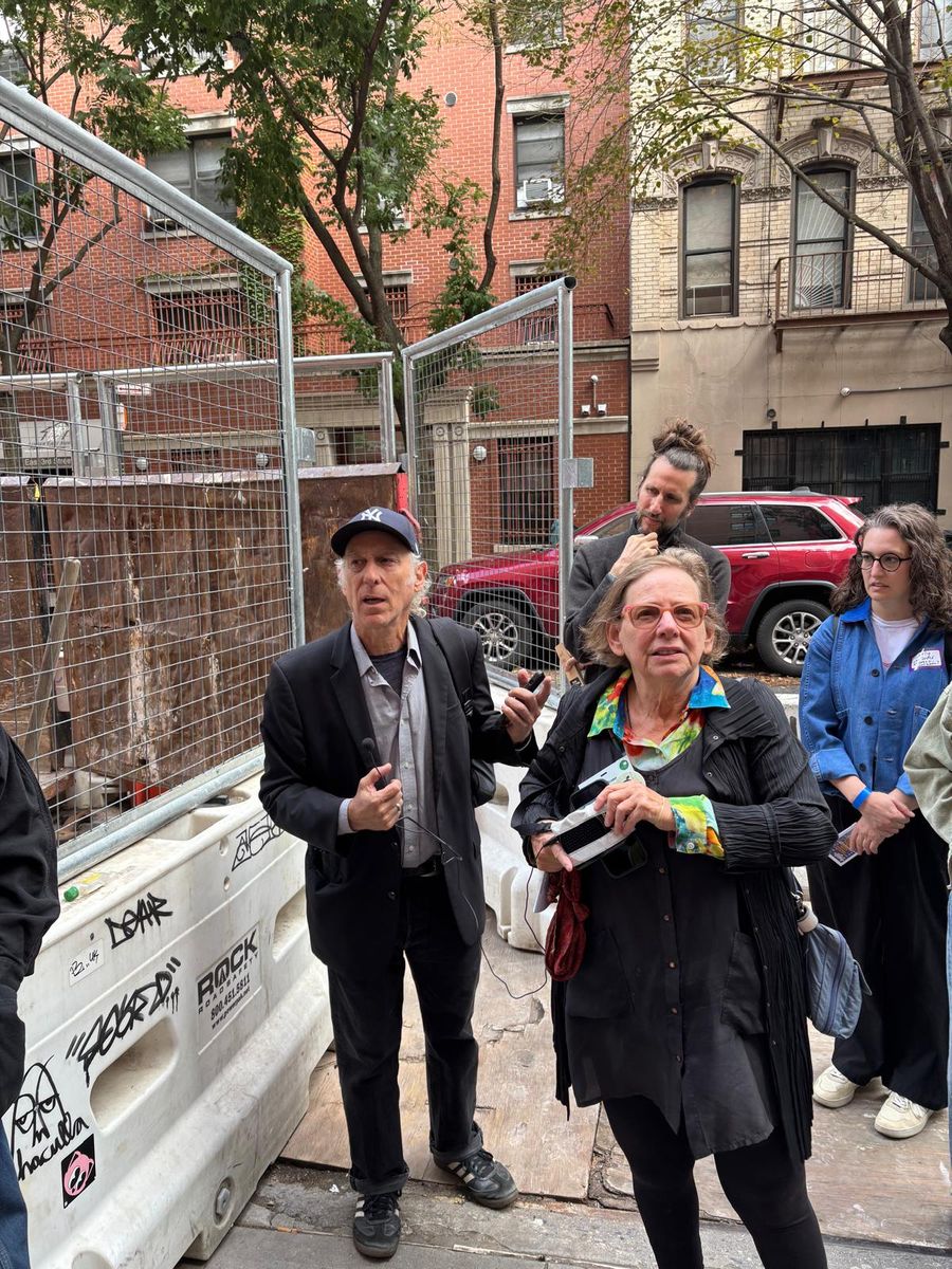 Wendy Brawer and a neighbor talking with the group beside the construction barriers on East 3rd Street.
