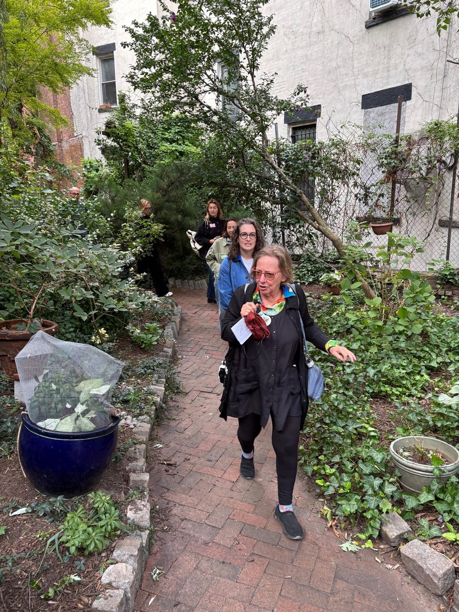 Wendy Brawer coming down the garden path between planters.