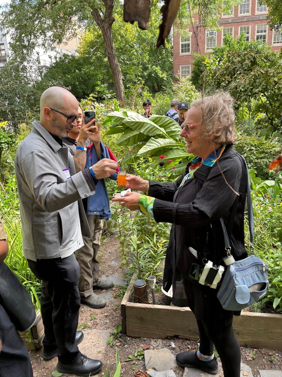 Wendy Brawer handing out small tomatoes from the garden.
