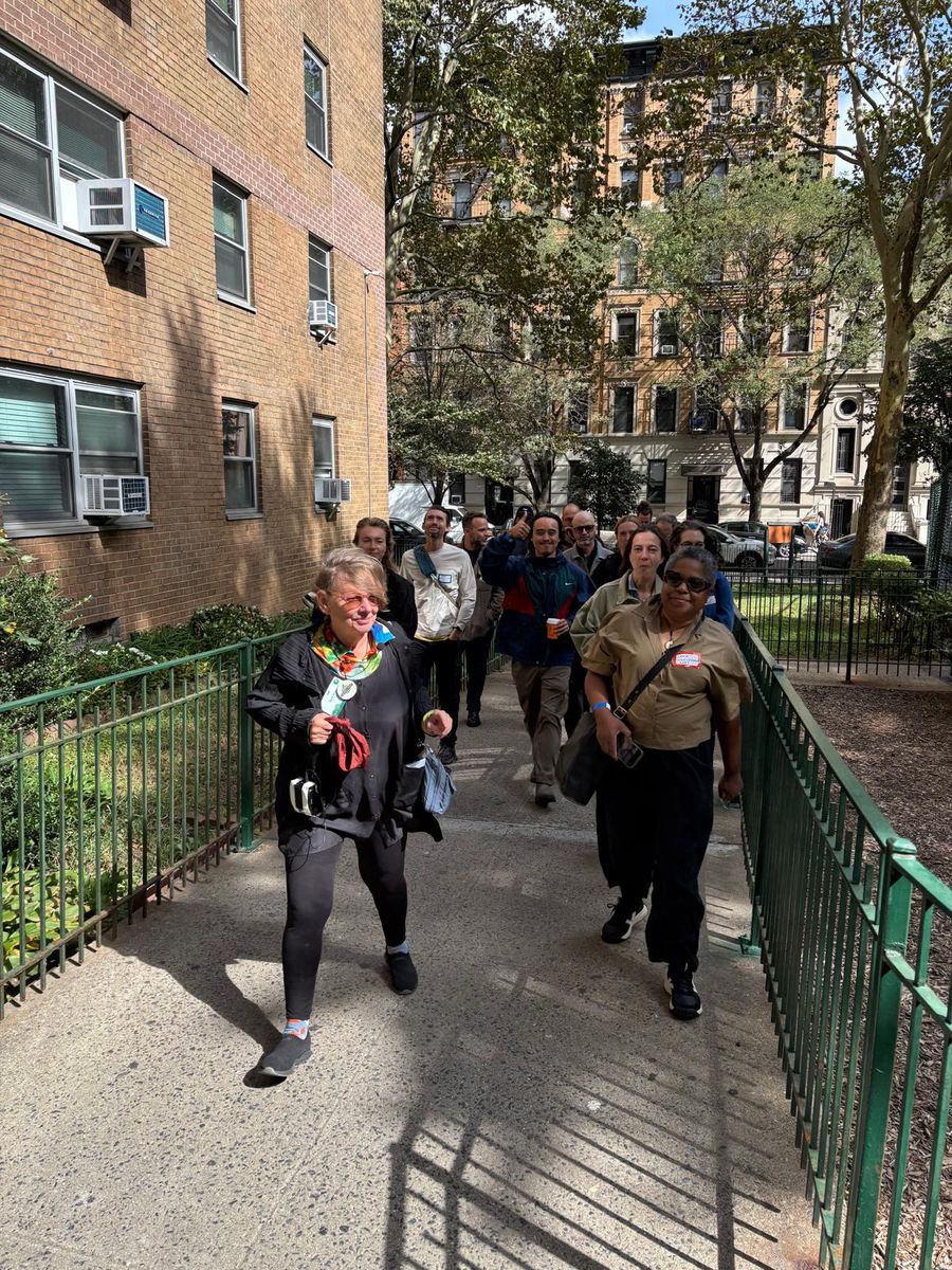 Wendy Brawer leading the group along a fenced path through Village View.