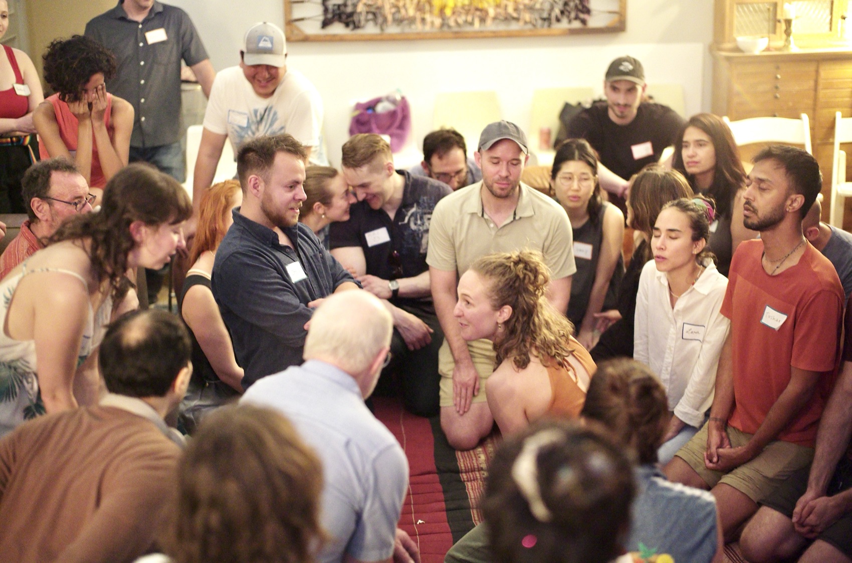 A close circle of attendees in conversation on the floor — the knee-to-knee texture of the evening.