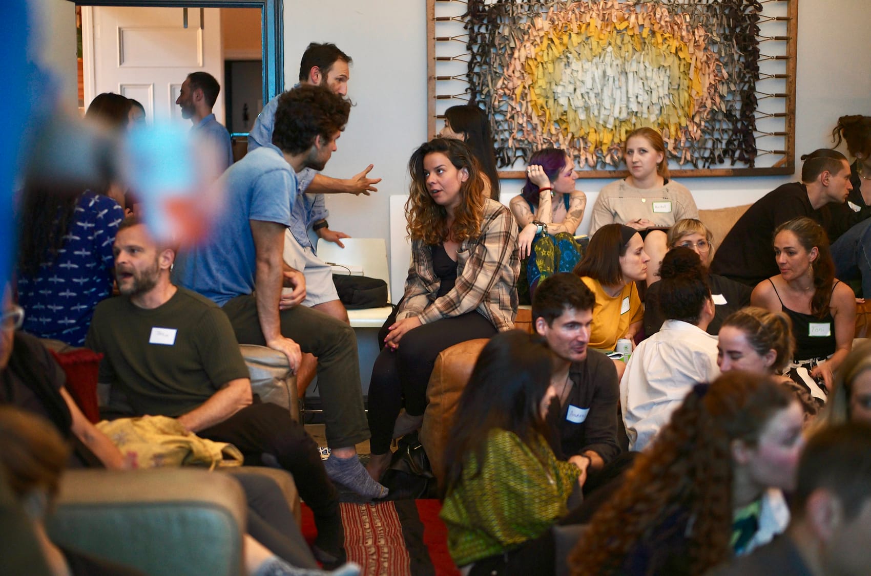 Breakout hum: pairs and threes in conversation across the full width of the living room.