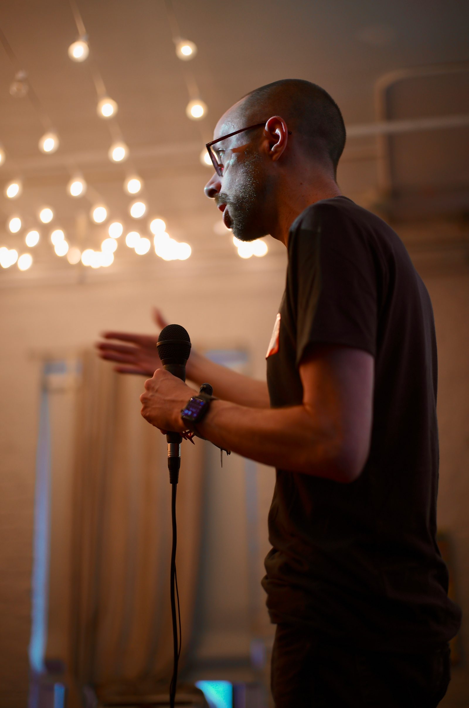 Jeff Sebo's hand around the microphone, backlit, mid-sentence. He spoke for two parts without slides.