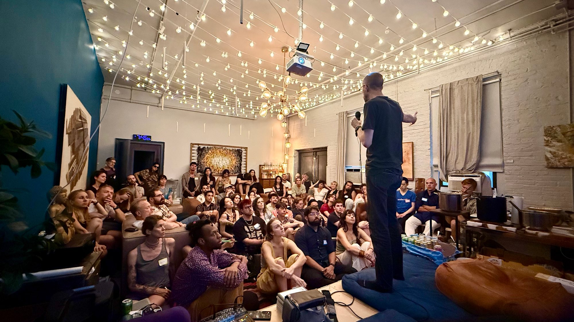 Jeff Sebo mid-talk, the room seated on every surface under the string lights.