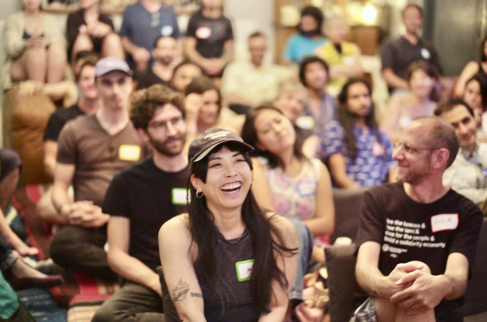 An attendee laughing out loud in the middle of the first half, the rows behind her still listening.
